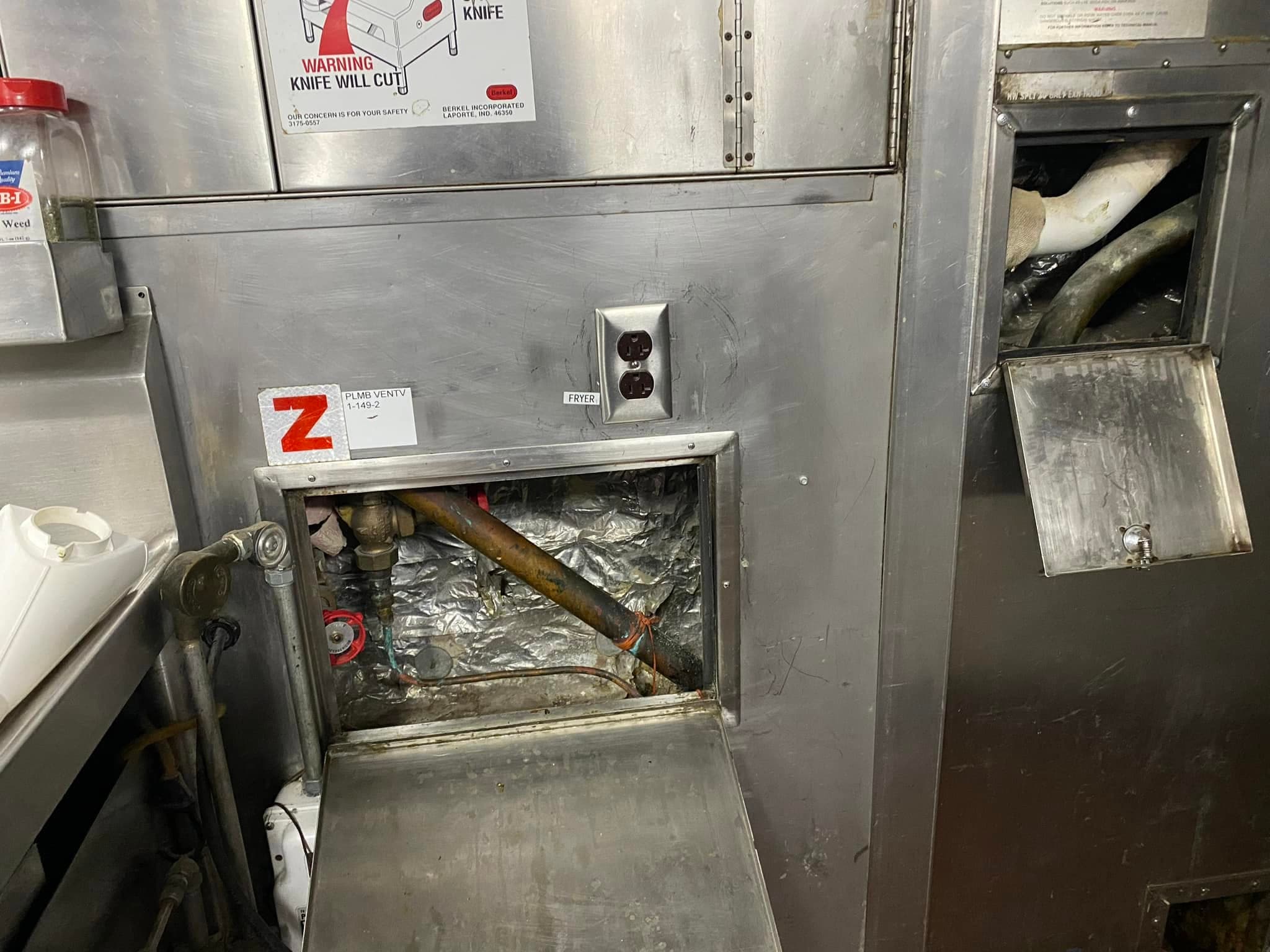 Commercial kitchen gas and plumbing access panel serviced by Newman's Plumbing